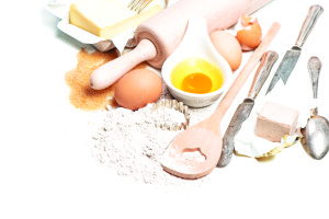 Baking ingredients eggs, flour, sugar, butter, yeast. Food background with antique cutlery